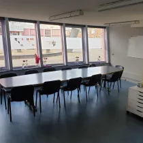 Deze vergaderruimte biedt plaats aan een groep deelnemers en heeft een frisse uitstraling dankzij de grote ramen. Ideaal voor zakelijke bijeenkomsten of trainingen.