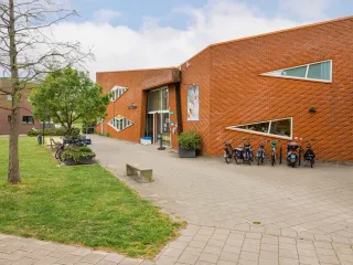 Zijaanzicht van het gebouw waarbij de fietsrekken goed te zien zijn