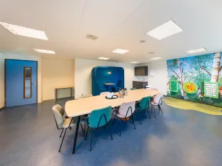 Er is een gezellige huiskamer aanwezig met een leuke speelhoek voor de kinderen en kleine werkplek