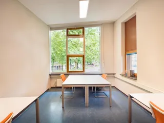 Op de 1e verdieping is een flexwerkplek aanwezig geschikt om in rust te werken of studeren. De witte bureaus met oranje stoelen maken het een fijne ruimte