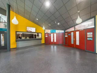 De centrale hal is praktisch ingericht. Er is een ontvangstbalie en deuren die leiden naar de verschillende zalen