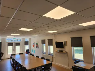 De cursusruimte biedt een praktische opstelling voor vergaderingen, trainingen of groepsbijeenkomsten. Met een ruime vergadertafel, comfortabele stoelen en moderne voorzieningen zoals een televisie en projectiemogelijkheden, is deze ruimte ideaal voor diverse doeleinden. Grote ramen laten veel natuurlijk licht binnen, wat zorgt voor een prettige werkomgeving.