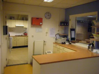 Een overzichtelijke bar of ontvangstbalie met toegang tot een aangrenzende keuken, ideaal voor het beheren van activiteiten en het ontvangen van gasten.