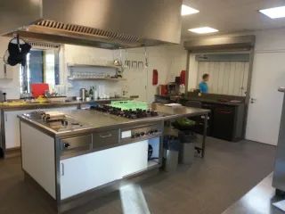 De keuken in het Buitenhuis is professioneel ingericht met ruime werkbladen, moderne apparatuur en praktische opbergruimte. Perfect geschikt voor kookactiviteiten en cateringdoeleinden.