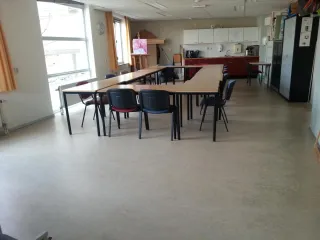 De creatieve ruimte op de bovenverdieping in Wippolder biedt een lichte en ruime opzet met werktafels, stoelen en een keukenblok. Ideaal voor creatieve workshops, vergaderingen of kleine bijeenkomsten.